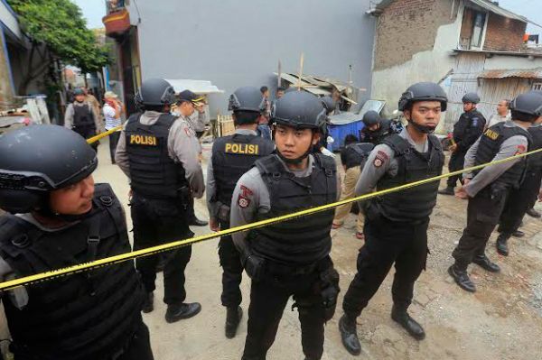 Polisi melakukan penjagaan di sekitar rumah penduduk
