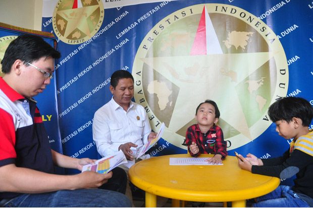 Kiyoshi Natanael Yohansyah saat diuji kemampuannya dalam menghafal, menulis, hingga menentukan letak 118 unsur kimia pada tabel periodik unsur kosong serta menyebutkan nomor atom secara acak di Kantor Leprid. Foto/SINDOnews/Ahmad Antoni